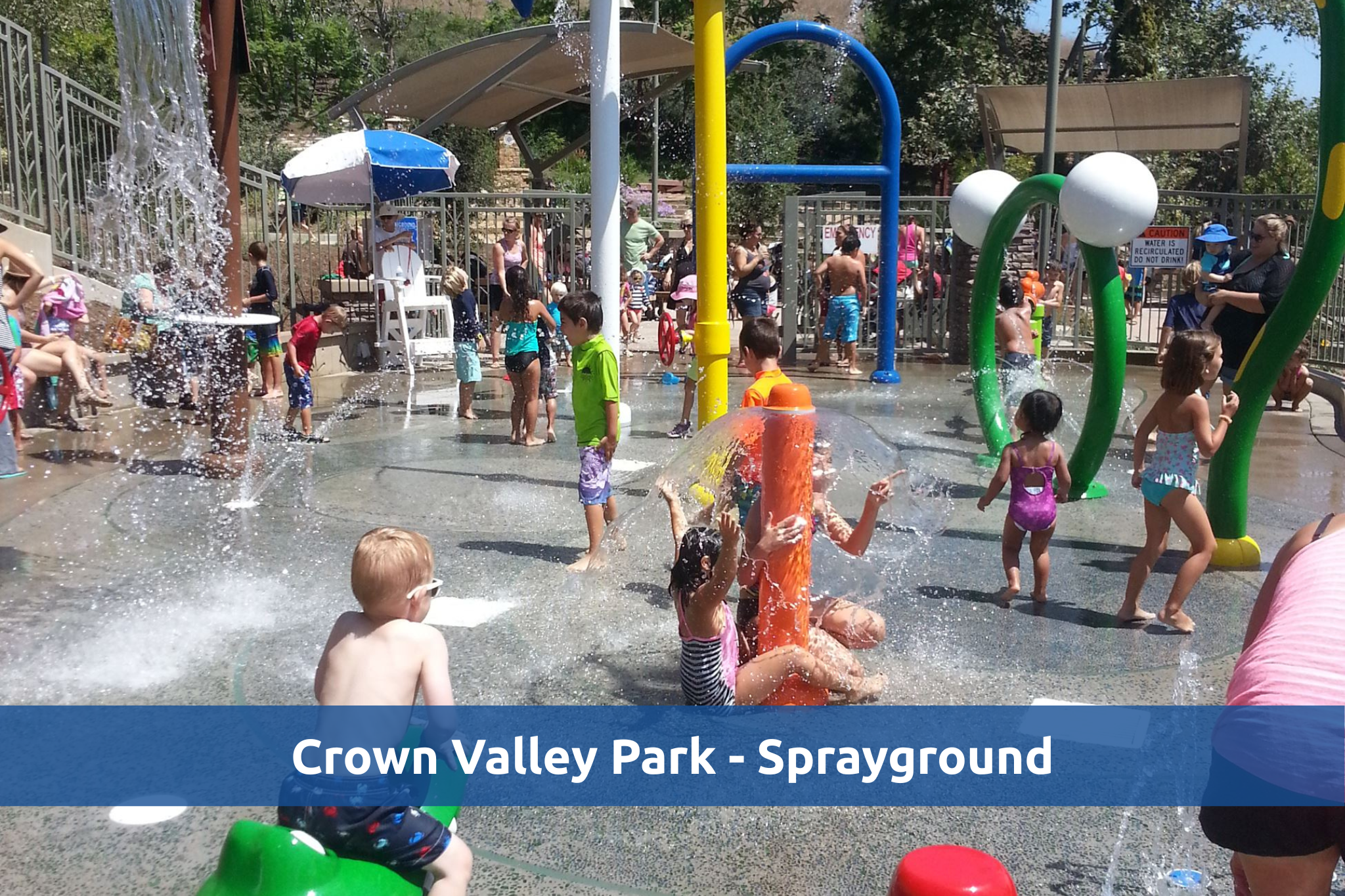 Sprayground at Crown Valley Park with kids playing in the water, in color